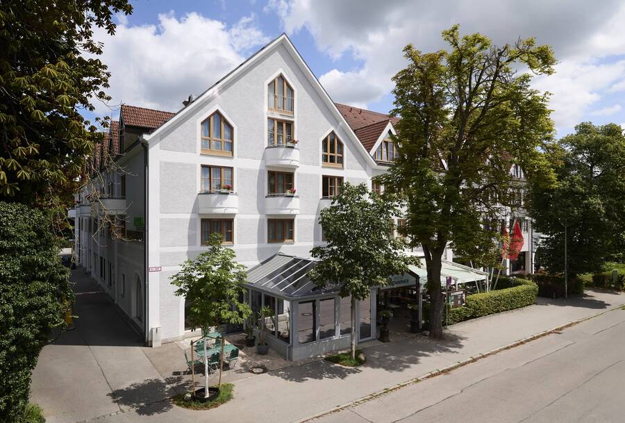 Außenansicht des Hotel Kastanienhof Erding mit Wintergarten, Terrasse und heller Fassade in ruhiger Lage.