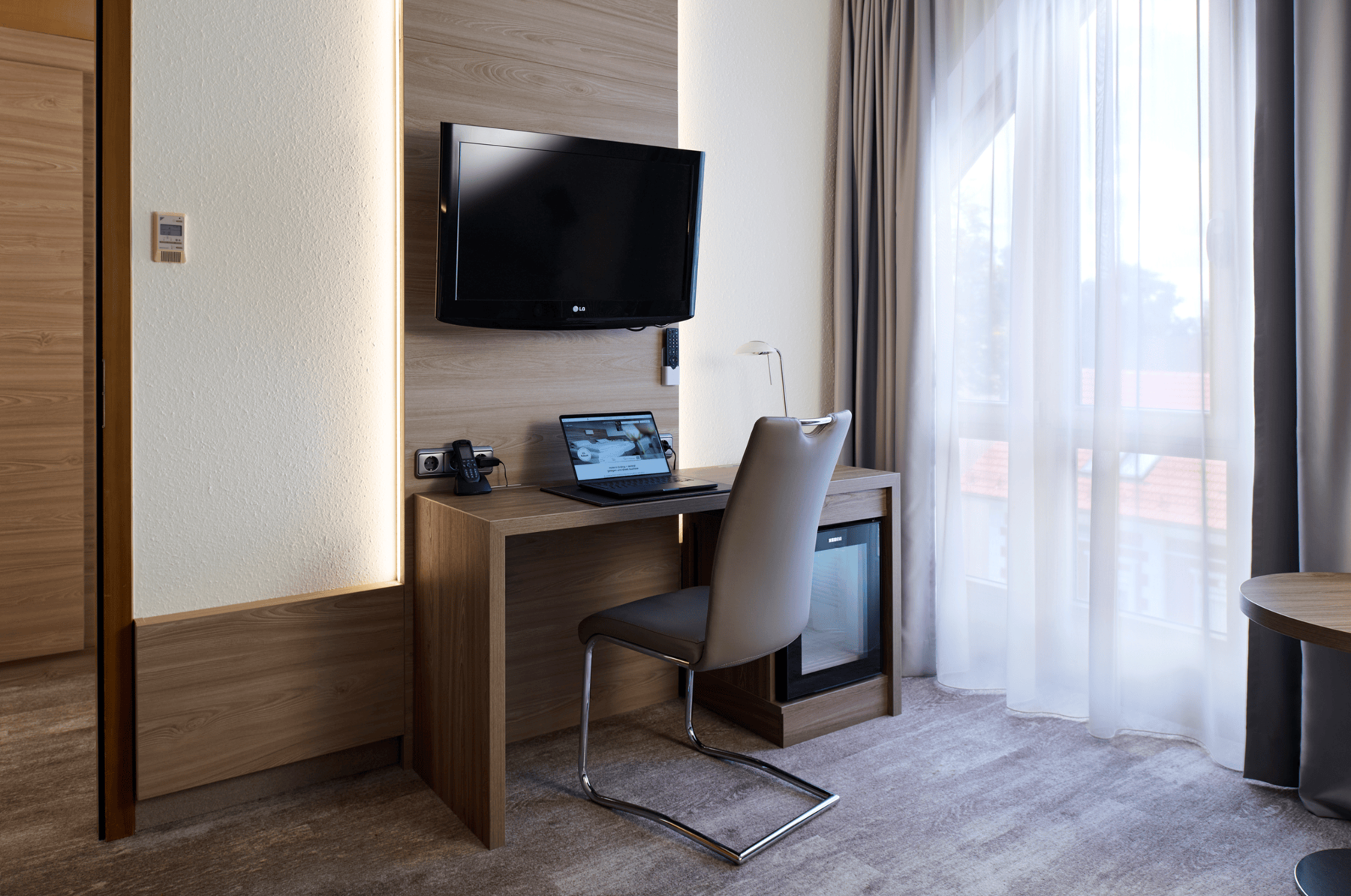 Modern work area in a double room at Hotel Kastanienhof Erding with desk, comfortable seating, flat-screen TV and a bright window area.