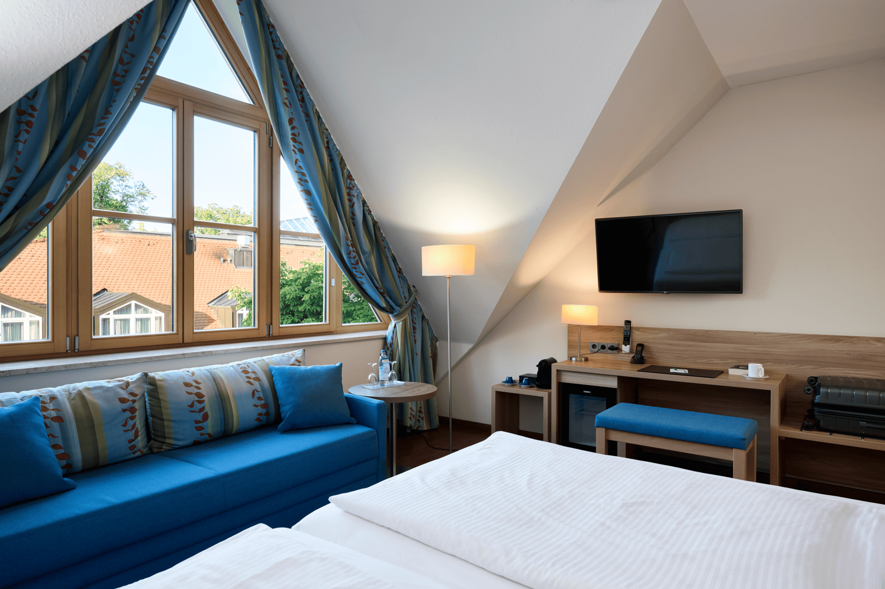 Spacious Executive Double Room at Hotel Kastanienhof Erding with sofa, workspace, flat-screen TV and plenty of natural light.
