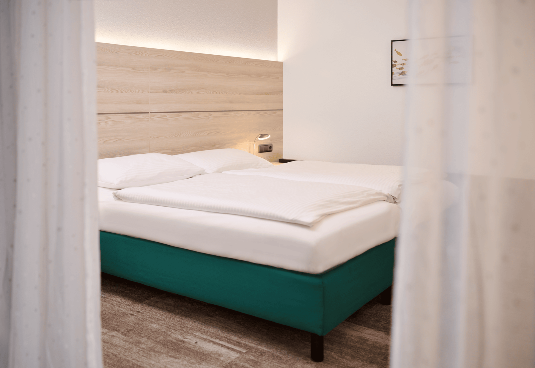 Comfortable sleeping area of the Junior Suite at Hotel Kastanienhof Erding with a spacious double bed and modern furnishings.