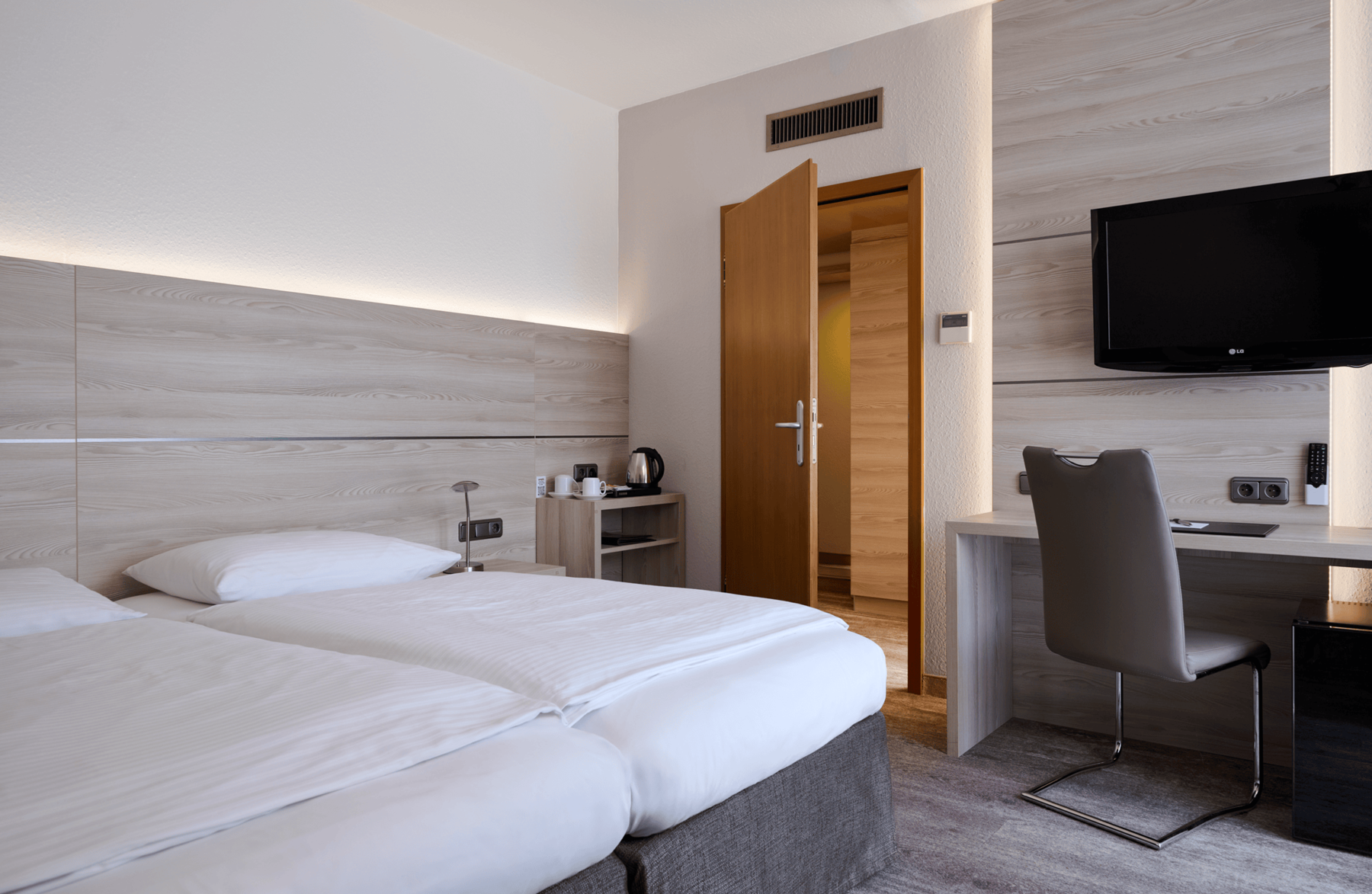 Bright double room at Hotel Kastanienhof Erding with a comfortable double bed, desk, flat-screen TV and modern furnishings.