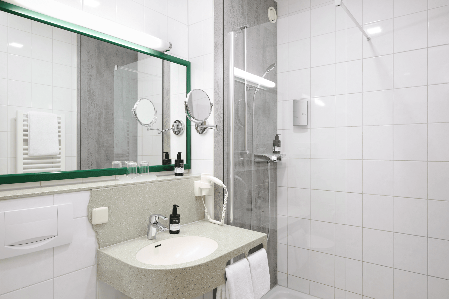 Bright bathroom in a double room at Hotel Kastanienhof Erding with shower, washbasin, large mirror and practical amenities.